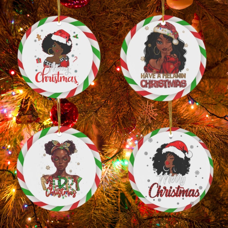 Puede incluir: Cuatro adornos navide&ntilde;os redondos con un borde de rayas de bast&oacute;n de caramelo rojo, blanco y verde. Cada adorno presenta a una mujer negra con cabello rizado que lleva un gorro de Pap&aacute; Noel. Los adornos tienen el siguiente texto: "Merry Christmas", "Merry Christmas", "Merry Christmas" y "Have a Melanin Christmas".
