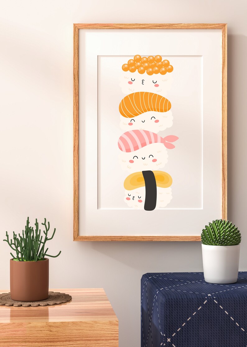 May include: A framed print of a stack of four sushi rolls with cute faces. The sushi rolls are topped with fish, shrimp, and egg.