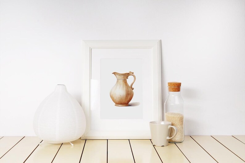 May include: A watercolor painting of a brown ceramic pitcher with a handle, framed in a white frame. The painting is displayed on a white shelf with a white diffuser and a glass jar with a cork lid.