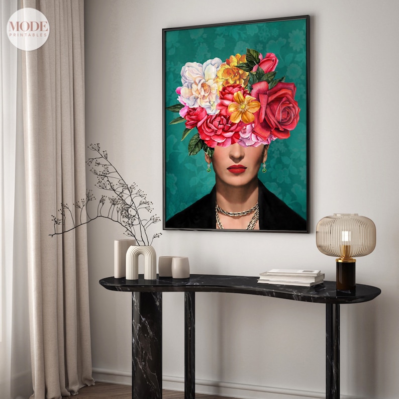 May include: A framed art print featuring a woman with a colorful floral arrangement covering her head. The background is a teal green with a floral pattern. The woman is wearing a black jacket and a gold necklace.