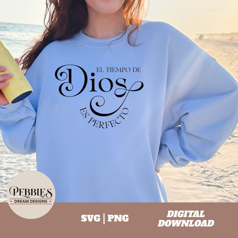 May include: A light blue sweatshirt with the text "El tiempo de Dios es perfecto" in black cursive lettering. The text is centered on the sweatshirt.