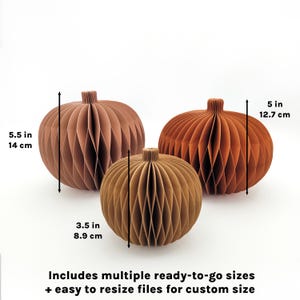 May include: Three paper pumpkins in shades of brown and orange, with dimensions of 5.5 inches (14 cm), 3.5 inches (8.9 cm), and 5 inches (12.7 cm). The text says "Includes multiple ready-to-go sizes + easy to resize files for custom size."