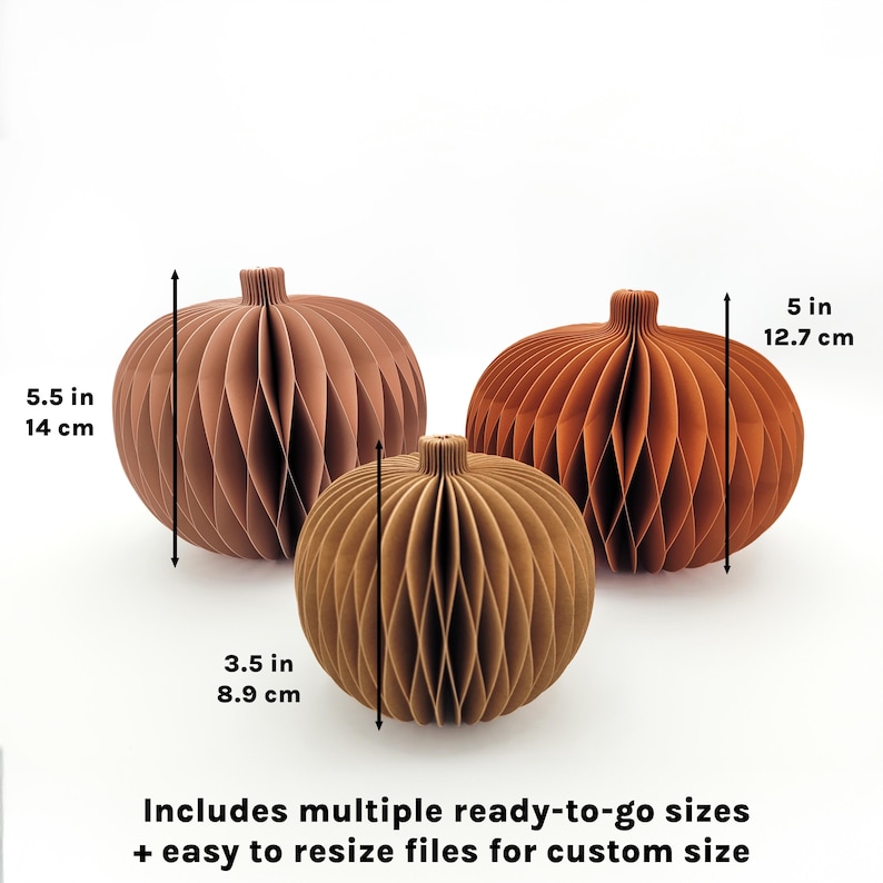 May include: Three paper pumpkins in shades of brown and orange, with dimensions of 5.5 inches (14 cm), 3.5 inches (8.9 cm), and 5 inches (12.7 cm). The text says "Includes multiple ready-to-go sizes + easy to resize files for custom size."