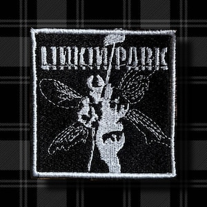 Op de afbeelding: Zwart-witte geborduurde patch met de bandnaam "Linkin Park" en een gestileerd insectendesign.