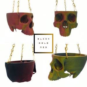 May include: Three hanging skull planters in black, gold, and red. The planters are made of ceramic and have a skull design. They are perfect for adding a touch of whimsy to your home decor.