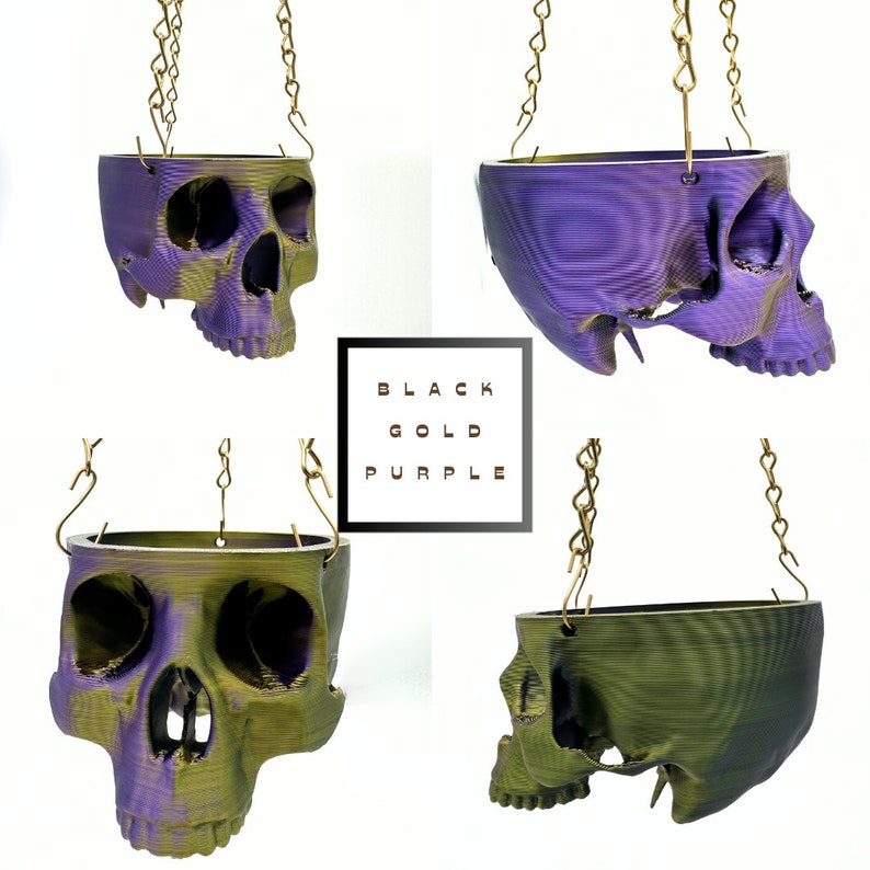 May include: Four hanging skull planters in black, gold, and purple. The planters are made of 3D printed plastic and have a textured surface. The chains are gold.