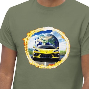 Op de afbeelding: Olijfgroen T-shirt met een afbeelding van een gele sportwagen op een weg, met de aarde op de achtergrond. De afbeelding is omcirkeld door een gele en oranje ring. Het T-shirt wordt door een persoon gedragen.