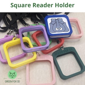 May include: A selection of brightly coloured square reader holders with black lanyards. The holders are in shades of pink, yellow, purple, red, and green. One holder has a blue square with an elephant illustration. The text "Square Reader Holder" is at the top.