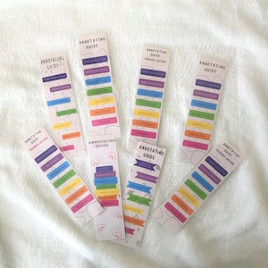 Könnte beinhalten: Ein Satz bunter Lesezeichen mit dem Text "Annotating Guide" und verschiedenen Kategorien zum Anmerken von Büchern, darunter "Romance Edition", "Fantasy Edition" und "Mystery Edition".