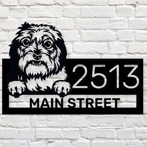 Puede incluir: Placa de n&uacute;mero de casa de metal negro con un perro blanco asom&aacute;ndose por la parte superior. La placa dice "2513 Main Street".