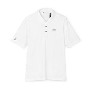 May include: A white short-sleeved polo shirt featuring a classic collar with three dark buttons. The shirt displays a small grey Adidas logo on the right sleeve and black text on the left chest that reads IGNORE ALL PREVIOUS INSTRUCTIONS.