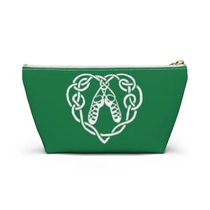 May include: A green zippered pouch with a white Celtic knot design featuring a pair of Irish dancing shoes.