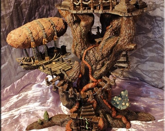 May include: A detailed fantasy treehouse model with multiple levels, bridges, and a hot air balloon. The tree is brown with intricate details, and the platforms are made of wood. Miniature figures stand at the base, adding scale to the scene.