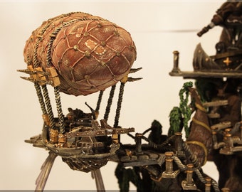 May include: A miniature model of a steampunk airship with a brown leather-like balloon, a wooden platform, and metal supports. The airship is attached to a larger wooden structure with a rope bridge.