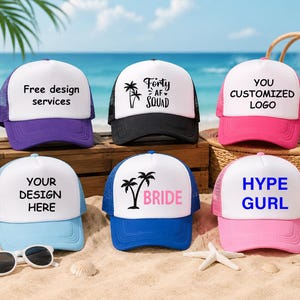 May include: Six trucker hats with white fronts and colored brims. The hats have text that reads "Free design services", "Forty AF Squad", "You customized logo", "Your design here", "Bride", and "Hype Gurl". The hats are on a wooden box and sand.