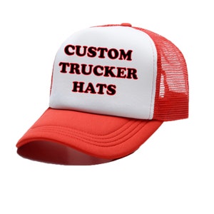 以下が含まれることがあります： 赤と白のトラッカーハットに、黒い文字で「CUSTOM TRUCKER HATS」と書いてあります。