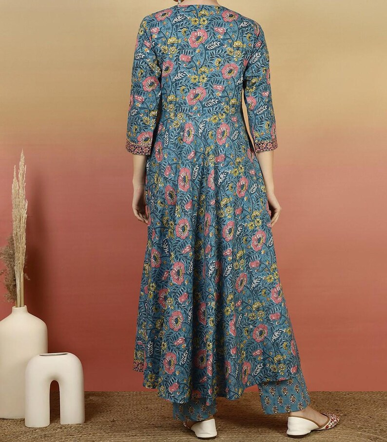 May include: A teal floral print kurta set. The long-sleeved top and matching pants feature a pattern of pink and yellow flowers. The kurta has a V-neck and a flared silhouette. The outfit is made of a lightweight fabric.