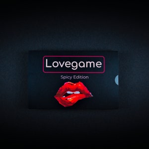 Könnte beinhalten: Eine schwarze Karte mit dem Text "Lovegame Spicy Edition" in Weiß und Rosa. Ein roter, gemalter, offener Mund mit weißen Zähnen befindet sich auf der Karte.
