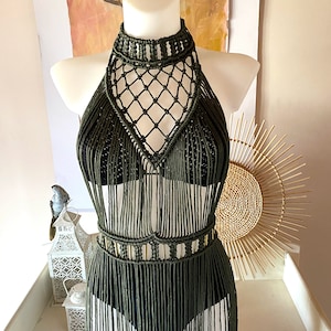 May include: A green macrame halter top with a fringe skirt. The top has a geometric design and the skirt is long and flowing.