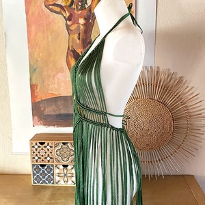 Op de afbeelding: Een groene gecrochete haltertop met franjes. De top wordt getoond op een wit mannequin.