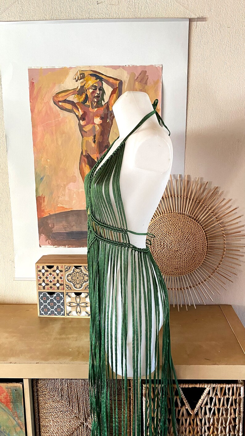 Op de afbeelding: Een groene gecrochete haltertop met franjes. De top wordt getoond op een wit mannequin.