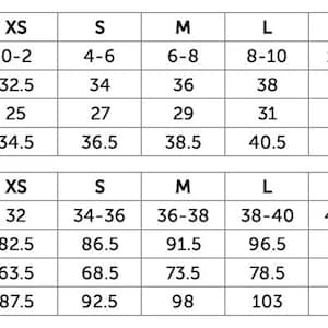 May include: A black and white size chart table displaying US and EU sizing conversions for clothing. The table lists measurements for bust, waist, and hip in inches and centimeters for sizes ranging from XS to XXL, providing a clear reference guide.