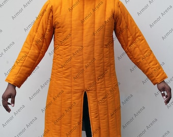 May include: An orange quilted gambeson, a padded garment worn under armor. The long-sleeved coat features vertical stitching, a high collar, and a front slit. The text "Armor Arena" is repeated across the image.