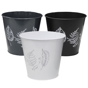 May include: Three metal planters, one white and two black, with a leaf design. The white planter has a fern and two leaves, while the black planters have a fern and a leaf.