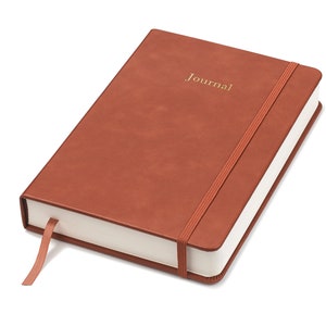 May include: A brown leather-bound journal with a gold elastic closure and the word "Journal" embossed on the front cover.