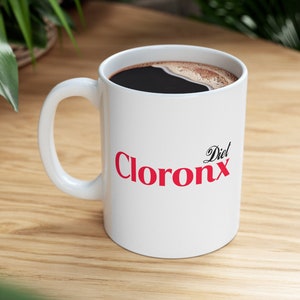 May include: White ceramic mug with a red "Diet Clorox" logo. The mug is filled with black coffee.