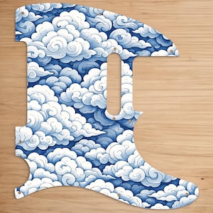 May include: A guitar pickguard with a blue and white cloud pattern. The pickguard has a unique shape with a long, vertical opening for the pickup and several screw holes. The cloud design is detailed and covers the entire surface.