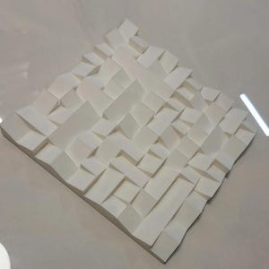 Könnte beinhalten: Weißer Akustikschaumstoff mit geometrischem Muster. Die Platte besteht aus einem weichen, schallabsorbierenden Material und ist so konzipiert, dass sie Geräusche reduziert und die Klangqualität verbessert.