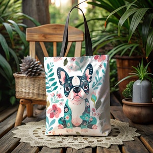 Puede incluir: Una bolsa de tela blanca con un dise&ntilde;o floral y una imagen de dibujos animados de un bulldog franc&eacute;s con un dise&ntilde;o de calavera de az&uacute;car. El bulldog lleva un pa&ntilde;uelo con estampado floral azul y verde.