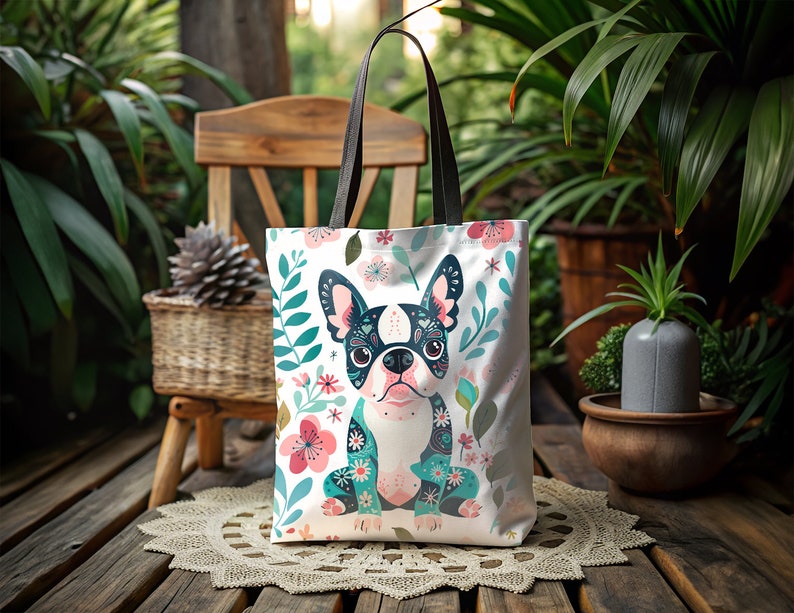 Puede incluir: Una bolsa de tela blanca con un dise&ntilde;o floral y una imagen de dibujos animados de un bulldog franc&eacute;s con un dise&ntilde;o de calavera de az&uacute;car. El bulldog lleva un pa&ntilde;uelo con estampado floral azul y verde.