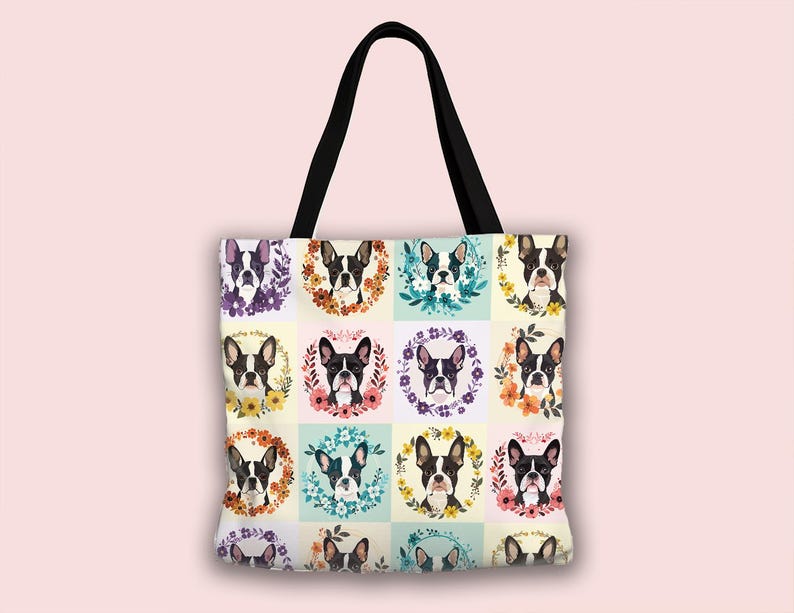 K&ouml;nnte beinhalten: Eine Tragetasche mit schwarzem Griff und einem sich wiederholenden Muster von Boston Terrier-Portr&auml;ts. Jeder Hund ist von einem Blumenkranz in verschiedenen Farben umgeben, vor einem hellgelben und blauen karierten Hintergrund. Die Tasche ist aus robustem Stoff.