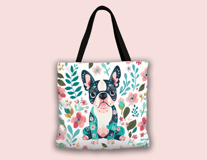Puede incluir: Una bolsa de tela blanca con asa negra presenta una ilustraci&oacute;n colorida de un perro Boston Terrier rodeado de flores rosas, azules y verdes.