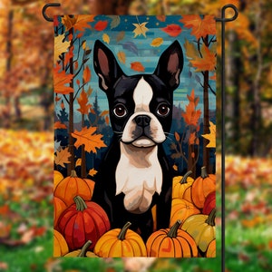 May include: A garden flag featuring a Boston Terrier dog surrounded by pumpkins and autumn leaves. The dog has black and white markings and is set against a backdrop of fall foliage. The pumpkins are orange and yellow.