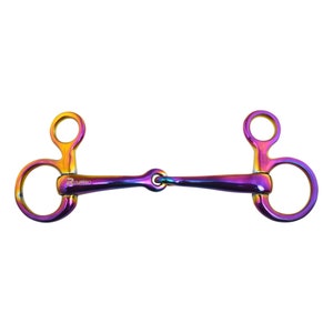 May include: A rainbow-colored metal horse bit with two rings on each side and a center ring. The bit is labeled "Raylea".