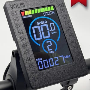 May include: Black electric bike display with a digital speedometer, odometer, and battery level indicator. The display shows a speed of 00.0 mph, an odometer reading of 00027 miles, and a battery level of 54 volts. The display also shows a PAS level of 2.
