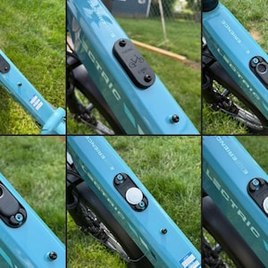 May include: Close-up shots of a light blue electric bicycle frame. The frame has the word "ELECTRIC" printed on it. A black control panel with a white button is visible. The bike is on a grassy surface.