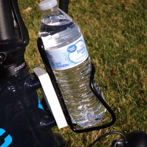 May include: A black bicycle water bottle holder with a clear plastic water bottle inside. The bottle is labeled "Great Value Purified Drinking Water".