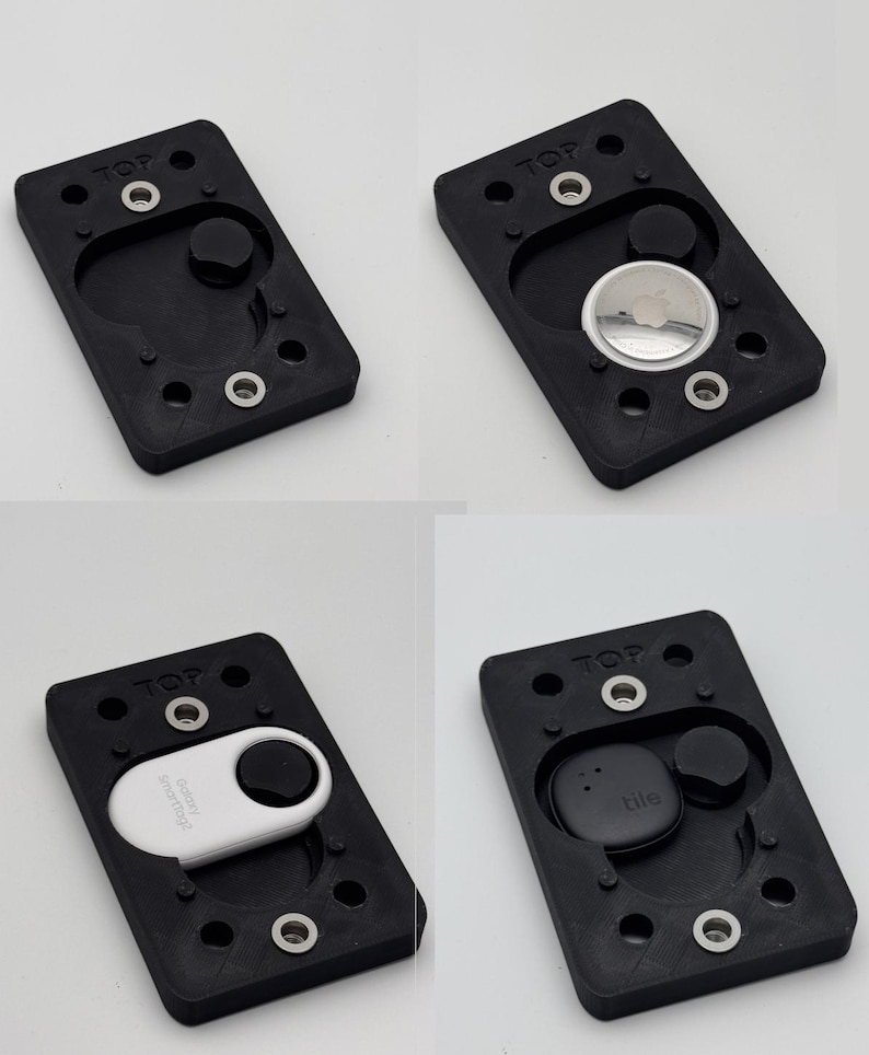 May include: A black rectangular holder with rounded edges, featuring a circular indentation and several screw holes. The word "TOP" is printed on the top. The holder is designed to accommodate various tracking devices, including an Apple AirTag, a Tile, and a SmartTag.