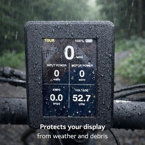May include: A black digital display screen with data readings, including speed, power, and voltage, is shown. The screen is encased in a textured black frame, with the text "Protects your display from weather and debris" at the bottom. The display is wet with raindrops.