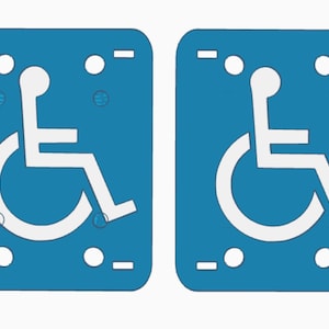 May include: Two blue rectangular signs with a white wheelchair symbol. Each sign has a rounded top and bottom, with white circles and dashes at the top and bottom. The wheelchair symbol is a stylized figure in a wheelchair.