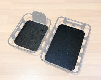 May include: Two black bike baskets with a textured surface. The larger basket has the word "ELECTRIC" printed on the bottom.
