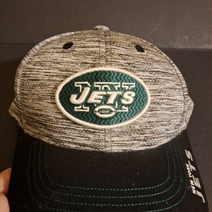 May include: A gray and black baseball cap with a green embroidered New York Jets logo. The cap has a black brim with green stitching.