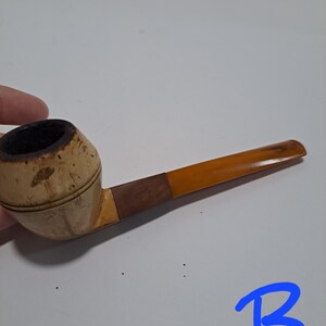 Op de afbeelding: Een houten rookpijp met een bruine en beige kom en een gele steel.