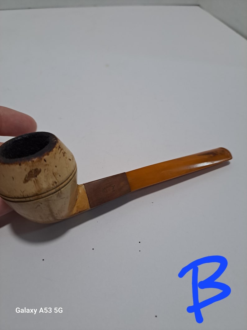 Op de afbeelding: Een houten rookpijp met een bruine en beige kom en een gele steel.