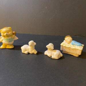 Baby Jesus, bear ornament, and two lambs