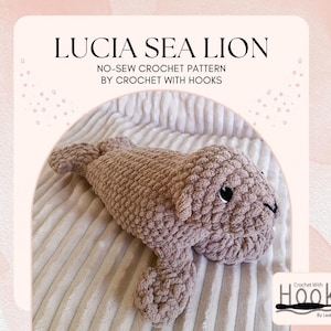 May include: A crocheted sea lion in a light brown color, lying on a white, textured surface. The sea lion has black eyes and a detailed, textured body. The text "LUCIA SEA LION" and "NO-SEW CROCHET PATTERN BY CROCHET WITH HOOKS" are visible.